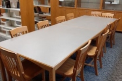 A picture of a conference table with chairs. 