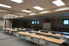 A picture of a large meeting room with tables and chairs