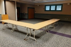 A picture of half of a large meeting room with tables and chairs